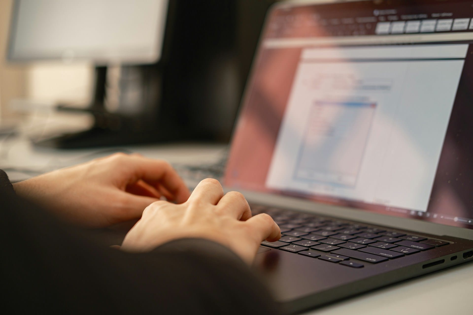 Gros plan de mains tapant sur le clavier d'un ordinateur portable.