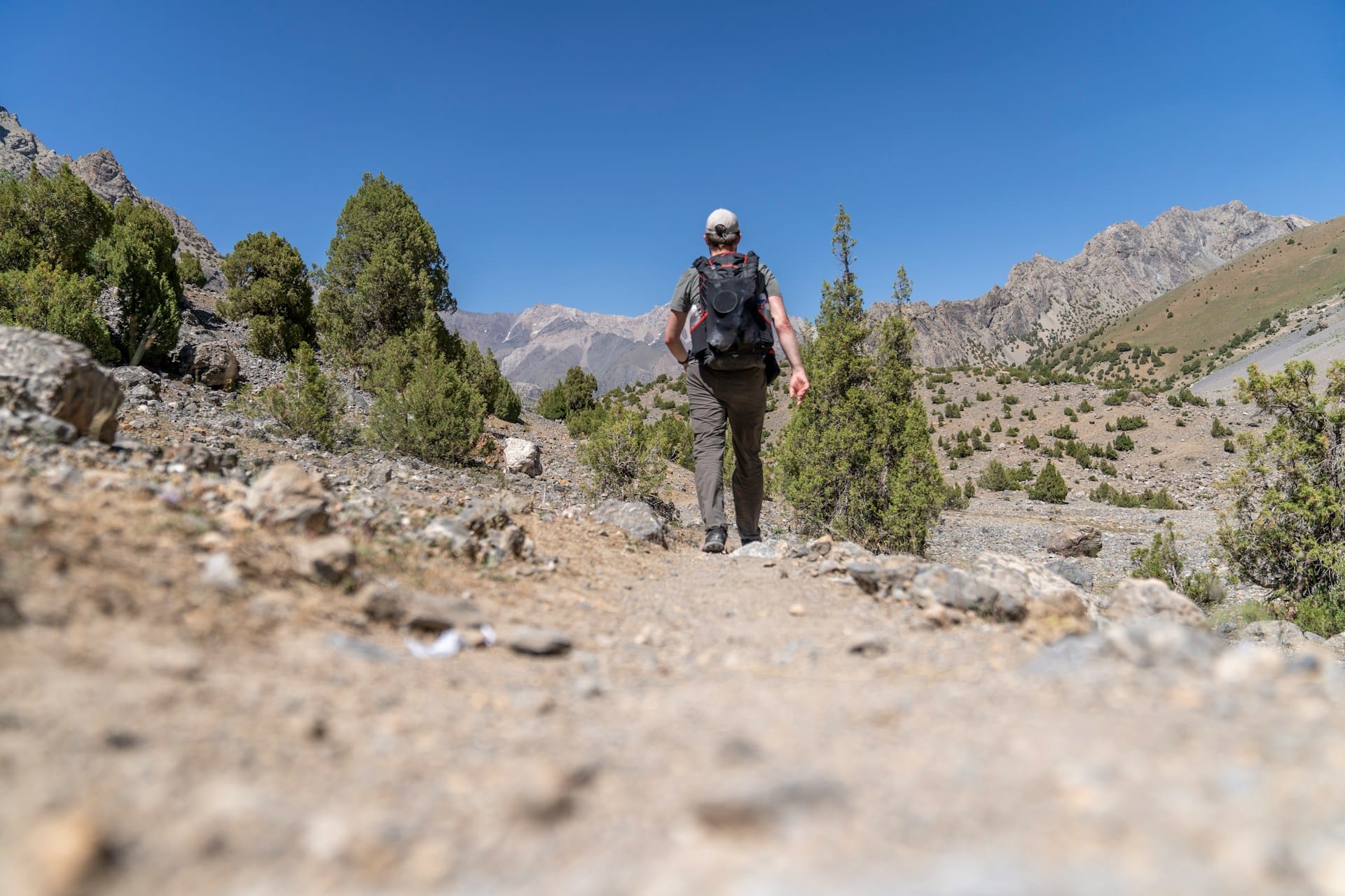 Un randonneur de dos sur un chemin pierreux.