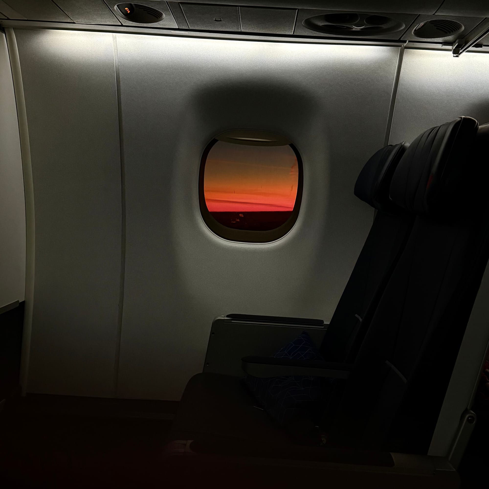 Lever de soleil au travers d'un hublot d'avion.