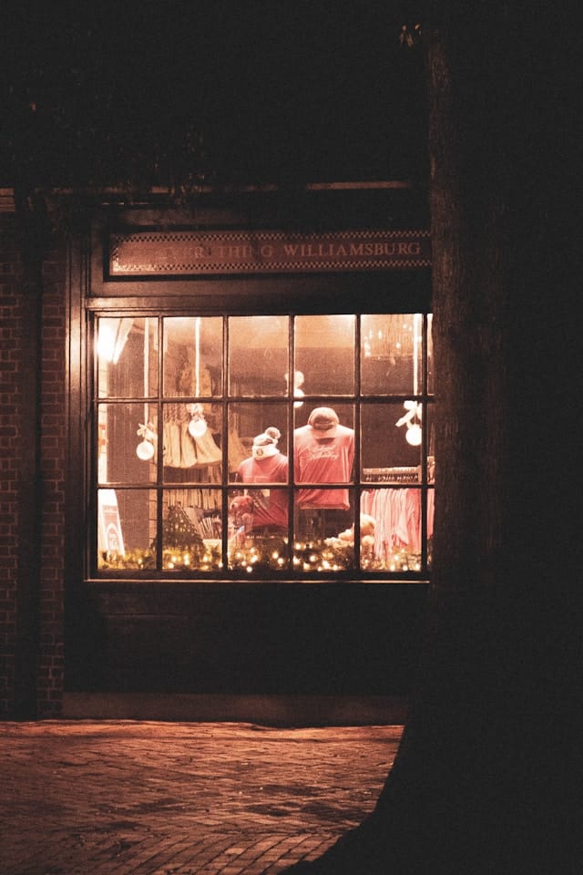 Une vitrine éclairée d'un magasin de vêtements pendant la nuit.