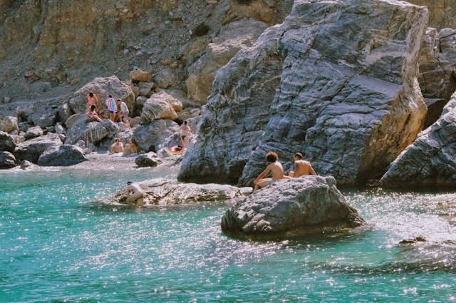 Une plage rocheuse avec quelques naturistes.