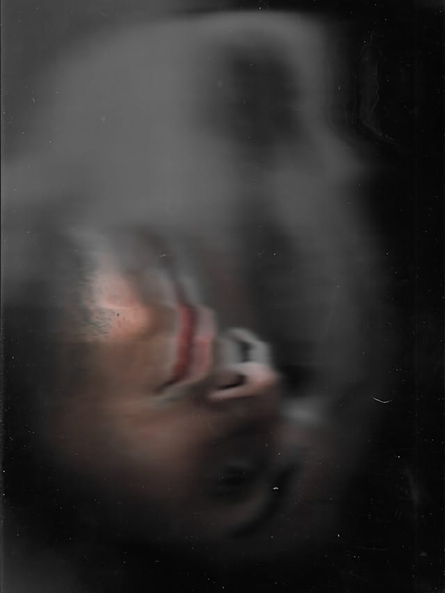 Visage humain flouté dont semble émaner un double spectral.