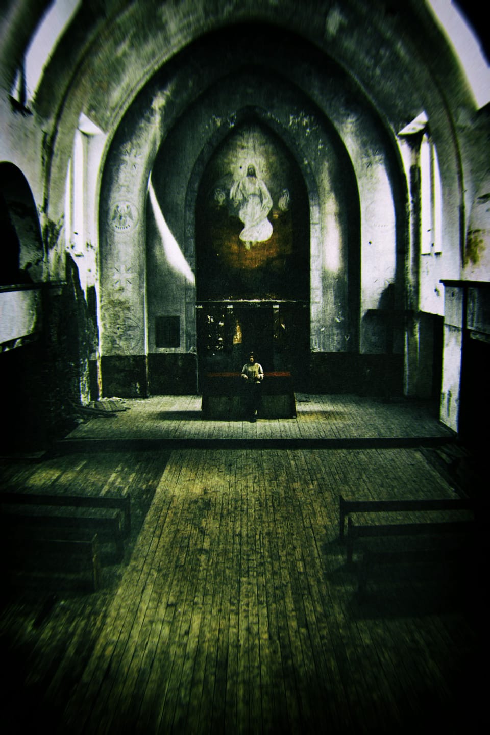 Une femme adossée à un autel dans une église délabrée.