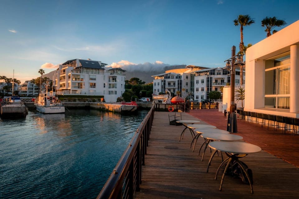 Une terrasse de café, ses tables avec vue sur le port. 