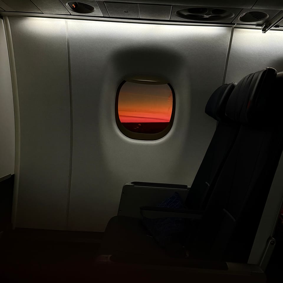 Lever de soleil au travers d'un hublot d'avion.